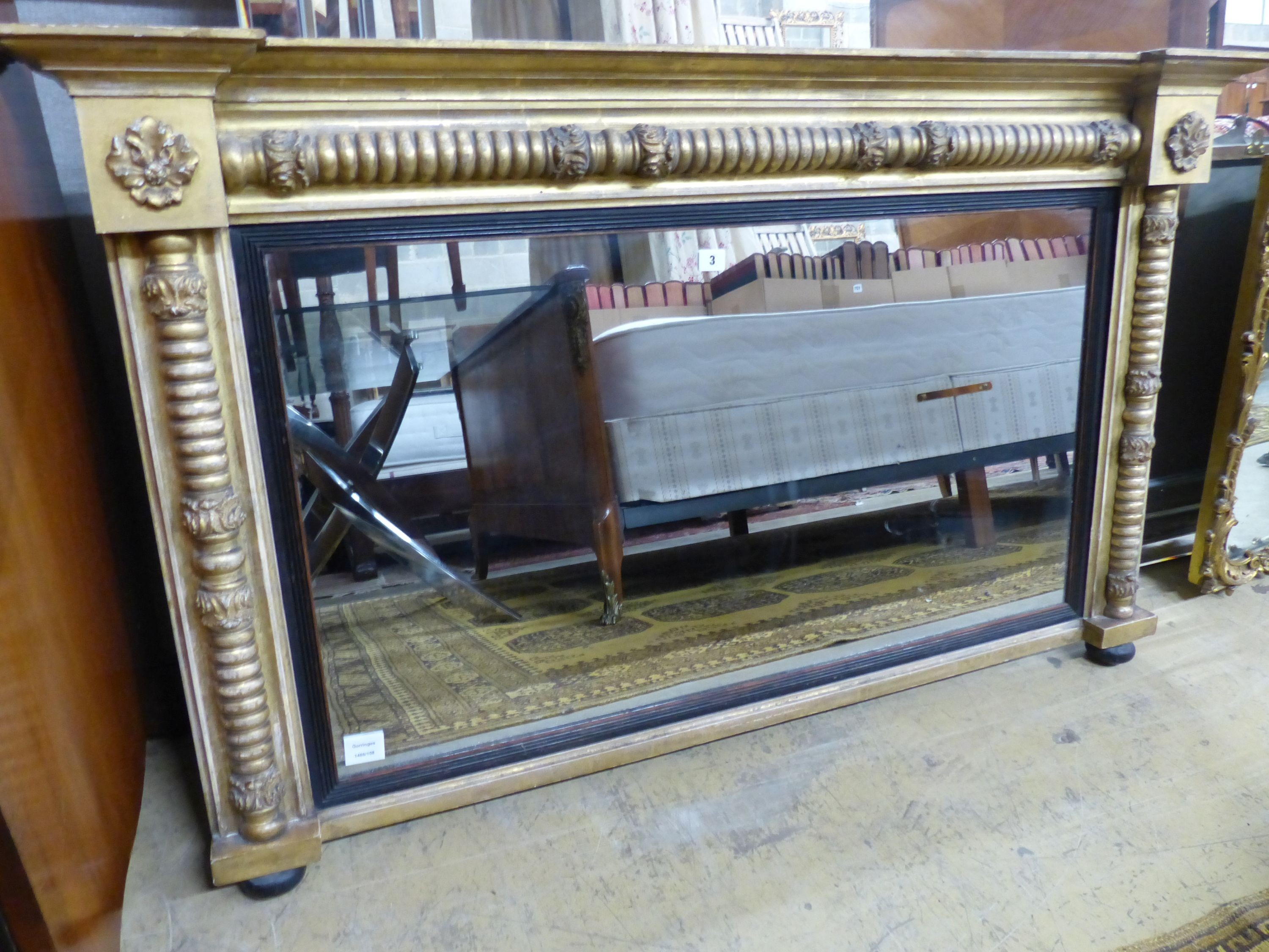 A Regency giltwood and gesso overmantel mirror, with ebonised slip, W.136cm H.81cm